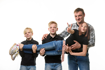 Image showing Dad and two sons hold a teenage girl in their arms, girl casual clothes in dark colors, white background
