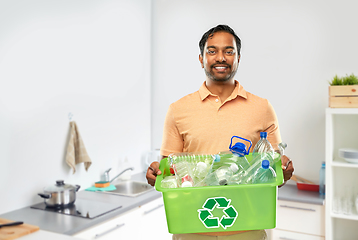 Image showing smiling young indian man sorting plastic waste