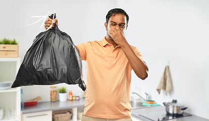 Image showing indian man holding stinky trash bag