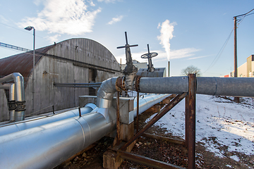 Image showing outdoor pipeline and old hangar in winter