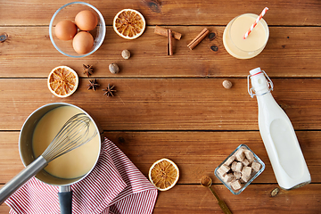 Image showing pot with eggnog, ingredients and spices on wood