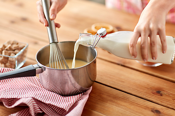 Image showing hands with whisk and milk cooking eggnog