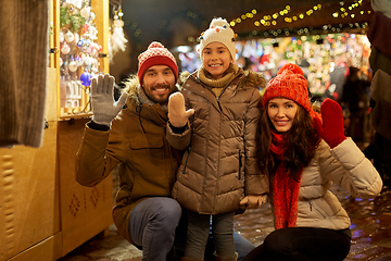 Image showing happy family waving hands at christmas market
