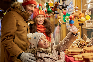 Image showing happy family buying souvenirs at christmas market