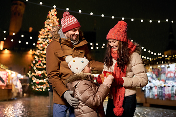 Image showing happy family with gift at christmas market in city