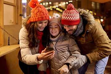 Image showing happy family with smartphone at christmas market