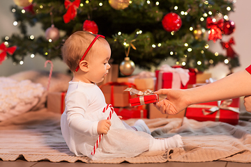 Image showing baby girl at christmas tree with gifts at home