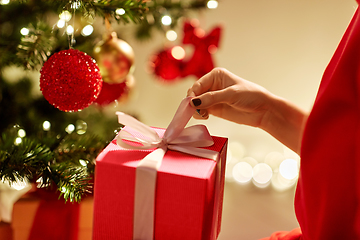 Image showing close up of woman with gift box at christmas tree