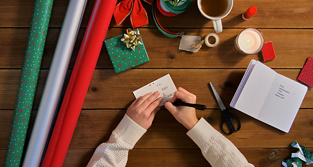 Image showing hands attaching name tag to christmas gift