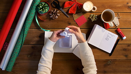 Image showing hands packing earphones for christmas gift