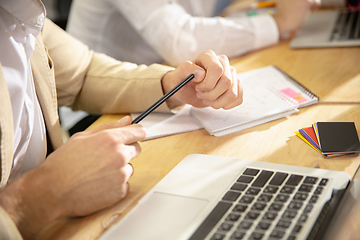 Image showing Hands of colleagues working together in a office using modern devices and gadgets during creative meeting. Close up.