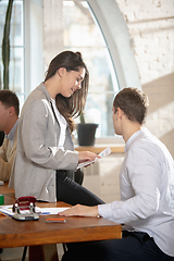 Image showing Side view colleagues working together in a office using modern devices and gadgets during creative meeting