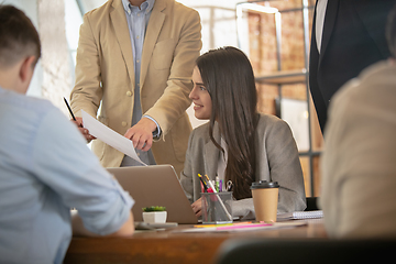 Image showing Front view colleagues working together in a office using modern devices and gadgets during creative meeting