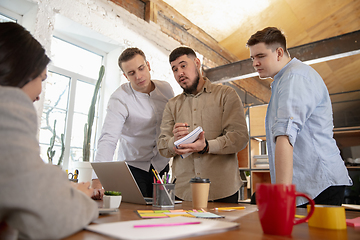 Image showing Front view colleagues working together in a office using modern devices and gadgets during creative meeting