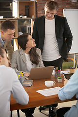 Image showing Front view colleagues working together in a office using modern devices and gadgets during creative meeting