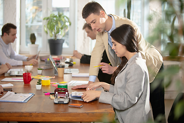 Image showing Side view colleagues working together in a office using modern devices and gadgets during creative meeting