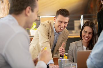 Image showing Front view colleagues working together in a office using modern devices and gadgets during creative meeting