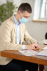 Image showing Man, manager working in a office using modern devices and gadgets during creative meeting