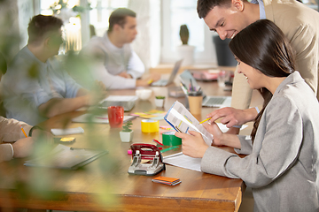 Image showing Side view colleagues working together in a office using modern devices and gadgets during creative meeting