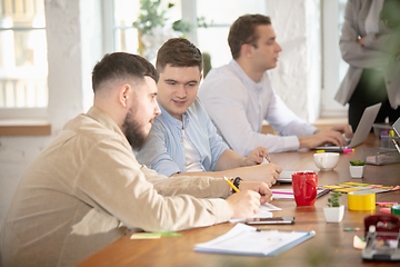 Image showing Side view colleagues working together in a office using modern devices and gadgets during creative meeting