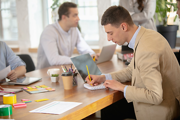 Image showing Side view colleagues working together in a office using modern devices and gadgets during creative meeting