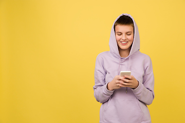 Image showing Caucasian girl\'s portrait isolated on yellow studio background with copyspace