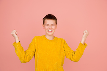 Image showing Caucasian girl\'s portrait isolated on coral pink studio background with copyspace