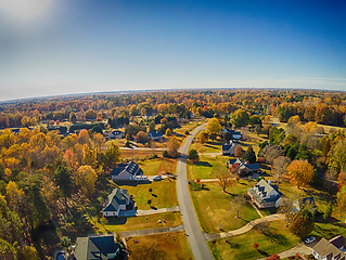 Image showing aerial view of colorful trees in a neighborhood before sunset