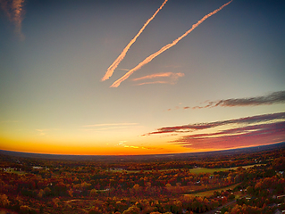 Image showing aerial view of colorful trees in a neighborhood before sunset