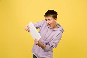 Image showing Caucasian girl\'s portrait isolated on yellow studio background with copyspace