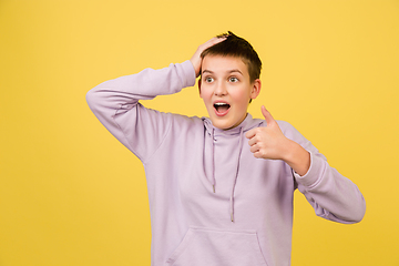 Image showing Caucasian girl\'s portrait isolated on yellow studio background with copyspace