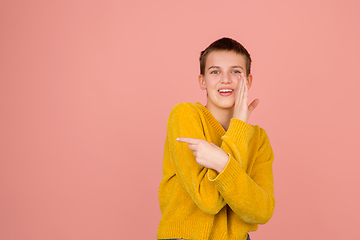 Image showing Caucasian girl\'s portrait isolated on coral pink studio background with copyspace