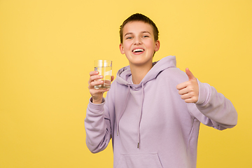 Image showing Caucasian girl\'s portrait isolated on yellow studio background with copyspace