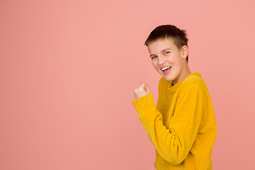 Image showing Caucasian girl\'s portrait isolated on coral pink studio background with copyspace