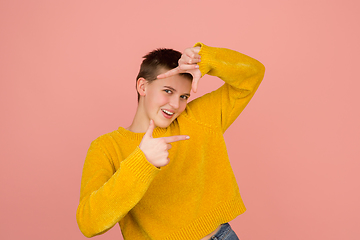 Image showing Caucasian girl\'s portrait isolated on coral pink studio background with copyspace