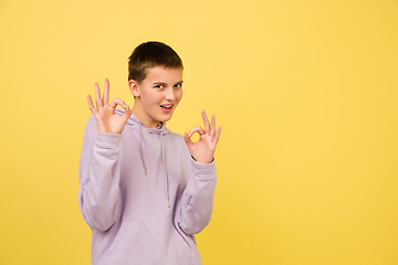 Image showing Caucasian girl\'s portrait isolated on yellow studio background with copyspace