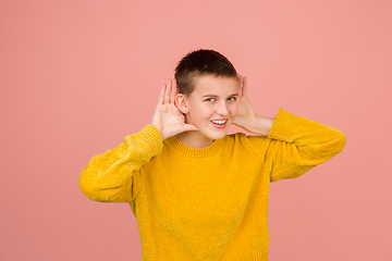 Image showing Caucasian girl\'s portrait isolated on coral pink studio background with copyspace