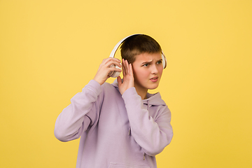 Image showing Caucasian girl\'s portrait isolated on yellow studio background with copyspace