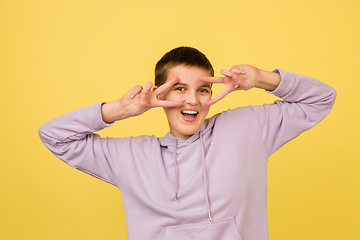 Image showing Caucasian girl\'s portrait isolated on yellow studio background with copyspace