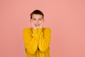 Image showing Caucasian girl\'s portrait isolated on coral pink studio background with copyspace