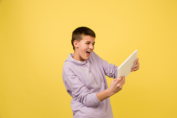 Image showing Caucasian girl\'s portrait isolated on yellow studio background with copyspace