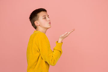 Image showing Caucasian girl\'s portrait isolated on coral pink studio background with copyspace