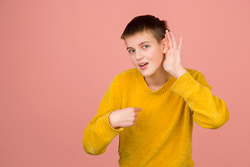 Image showing Caucasian girl\'s portrait isolated on coral pink studio background with copyspace