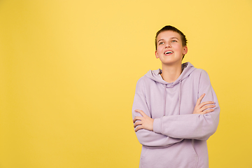 Image showing Caucasian girl\'s portrait isolated on yellow studio background with copyspace