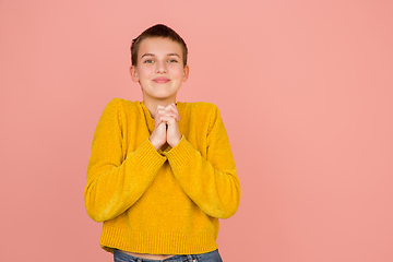 Image showing Caucasian girl\'s portrait isolated on coral pink studio background with copyspace