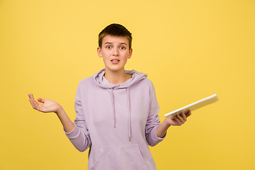 Image showing Caucasian girl\'s portrait isolated on yellow studio background with copyspace