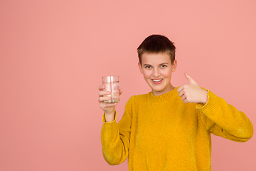 Image showing Caucasian girl\'s portrait isolated on coral pink studio background with copyspace