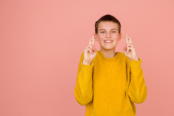 Image showing Caucasian girl\'s portrait isolated on coral pink studio background with copyspace