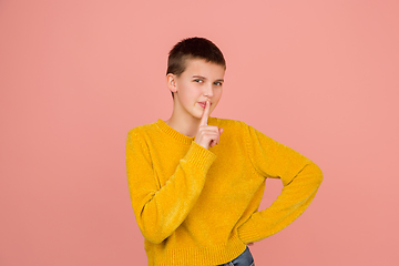 Image showing Caucasian girl\'s portrait isolated on coral pink studio background with copyspace