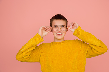 Image showing Caucasian girl\'s portrait isolated on coral pink studio background with copyspace